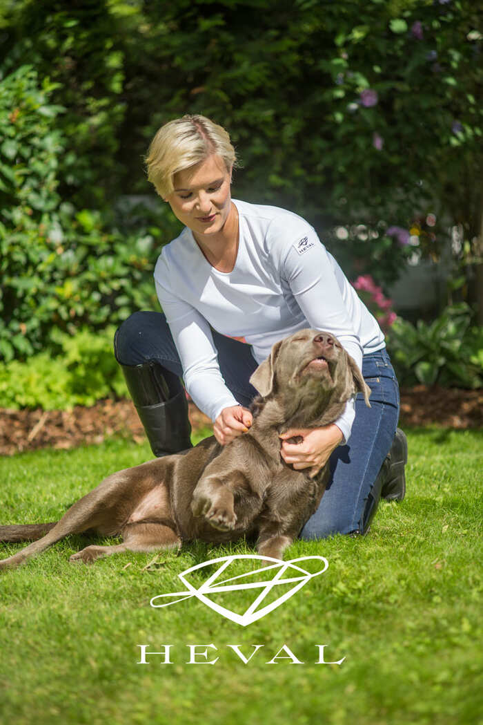 Junge Frau schmust mit Hund auf Rasen